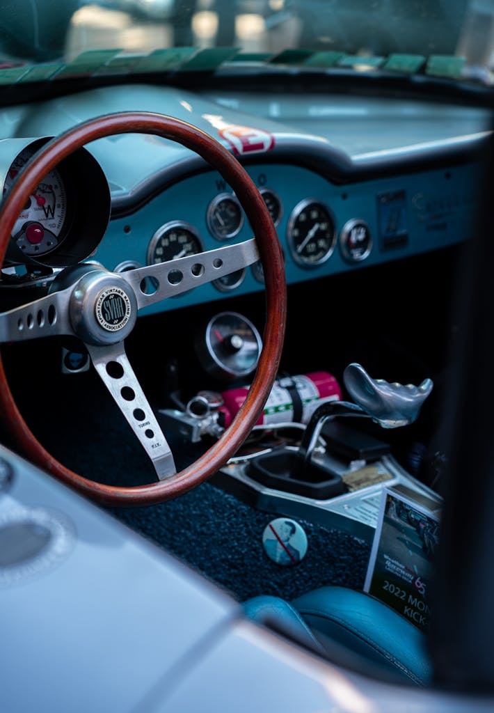 Explore a close-up view of a vintage car's dashboard featuring a wooden steering wheel.