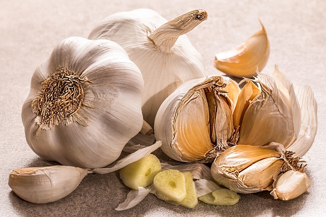 Garlic Bulb On A Cutting Board With A Knife And Fresh Herbs