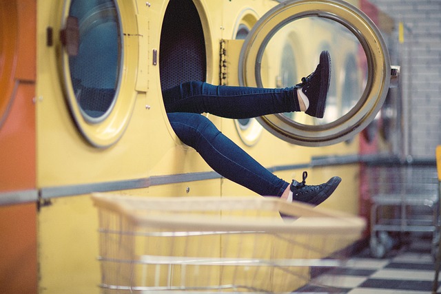 Laundromat Interior With Coin-operated Machines And Customers Doing Laundry