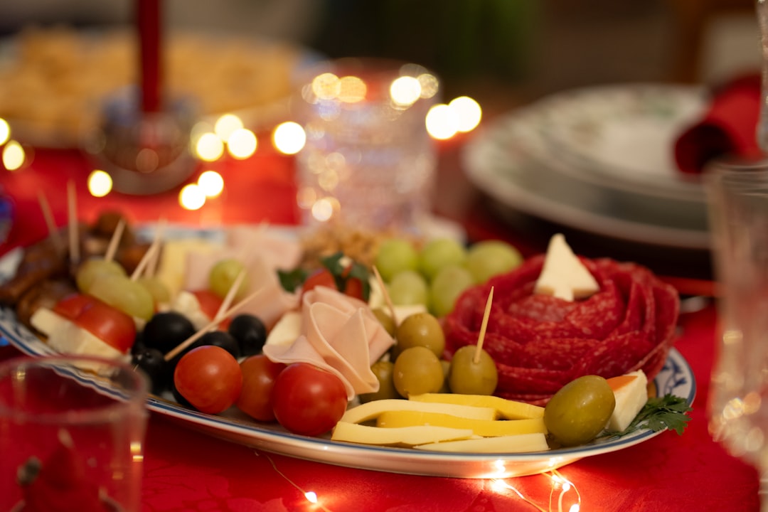 Holiday Wreath Charcuterie Board With Rosemary, Mozzarella Balls, Cherry Tomatoes, Cheese Cubes, And Folded Salami