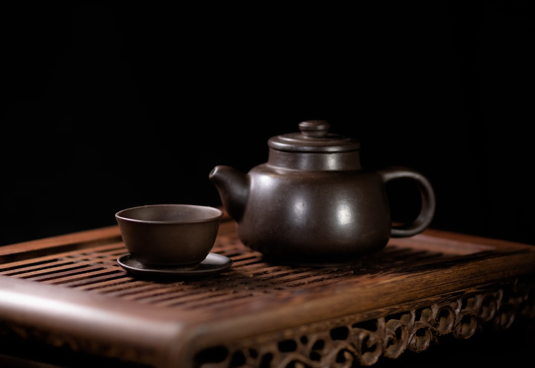 Gentian Root Tea In A Glass Cup On A Wooden Table With Herbs And A Teapot In The Background