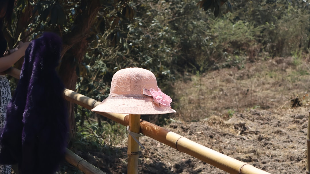 Wide-brimmed Hat On A Model With An Oval Face Shape In A Stylish Outdoor Setting