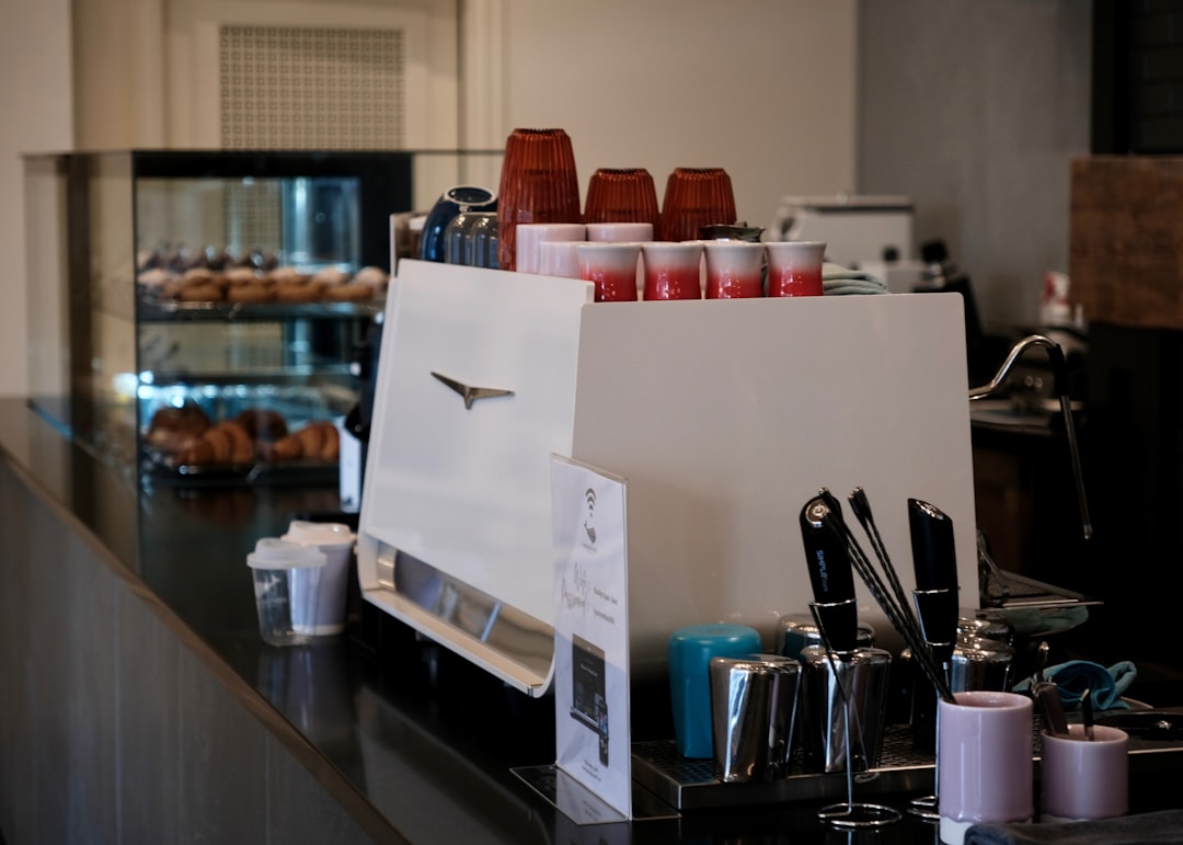 Coffee Shop Interior With Customers Ordering Lattes At The Counter
