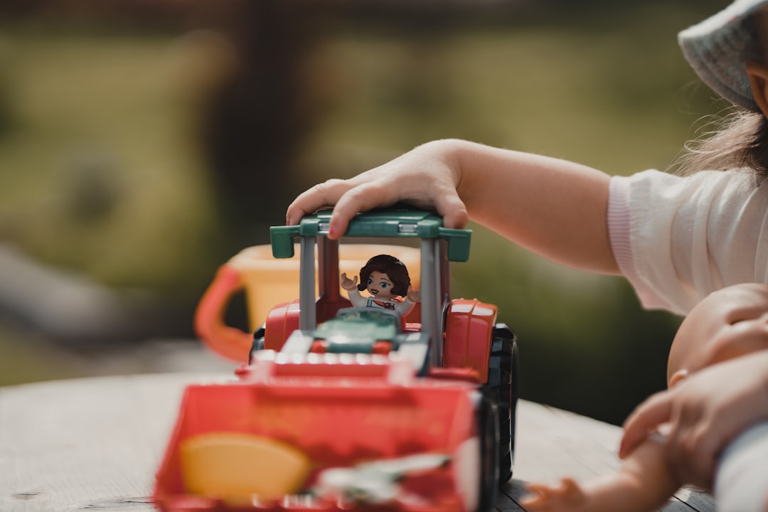 Gender-neutral Parenting Scene With Children Playing With Trucks And Dolls
