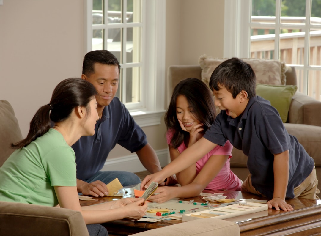 Family Engaged In Activities Like Reading Physical Books And Playing Board Games, With Devices Out Of Sight