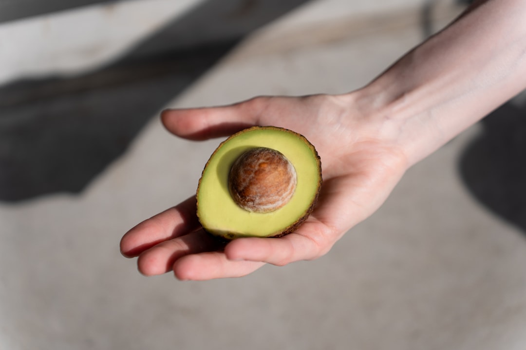 Ripe Avocado In Hand Gently Squeezed