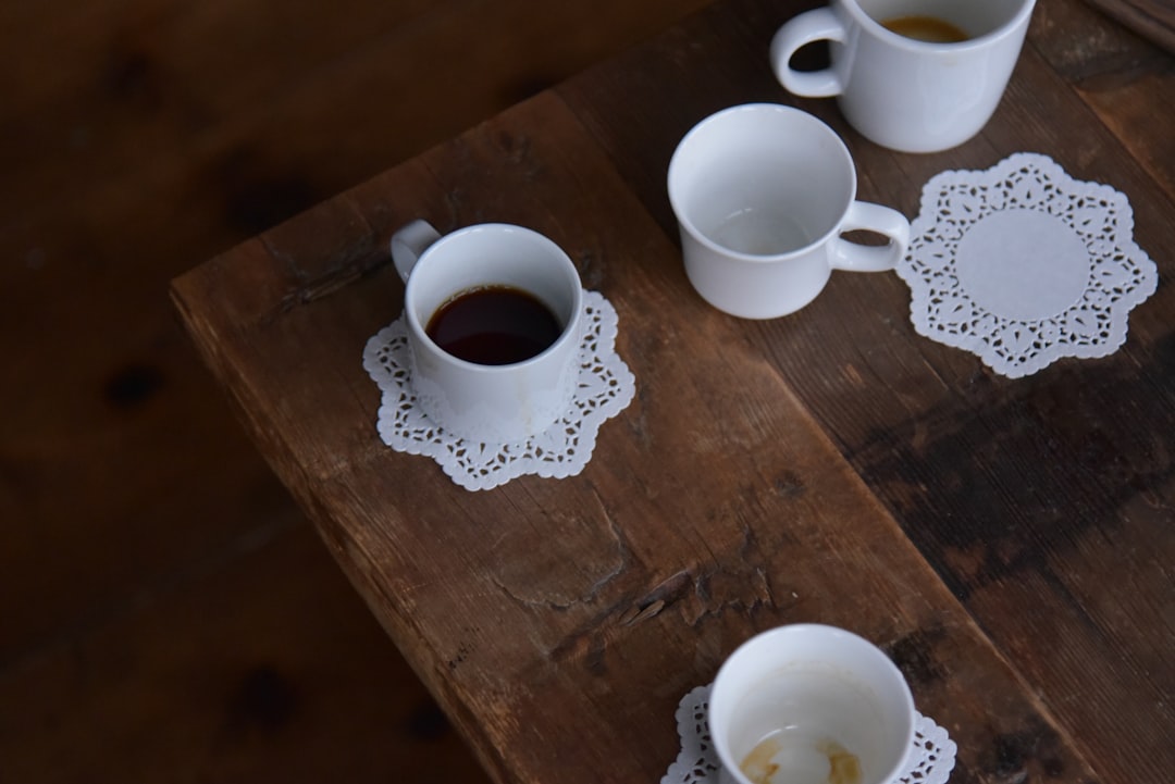 Black Tea In A Cup With Steam Rising, Surrounded By Loose Tea Leaves And A Slice Of Lemon On A Wooden Table