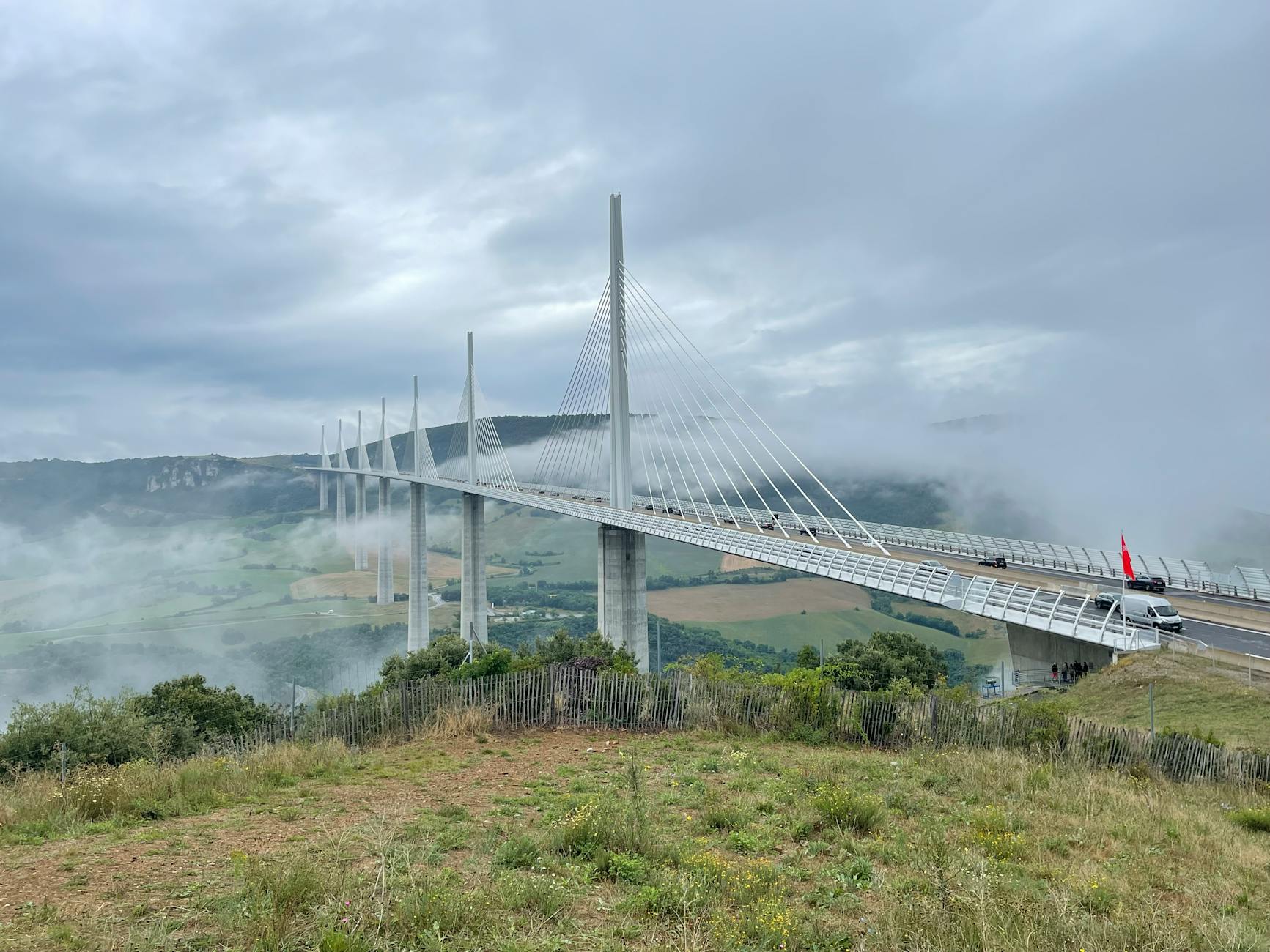 Millau Viaduct Bridge In Southern France Above Clouds With Valley Landscape Below