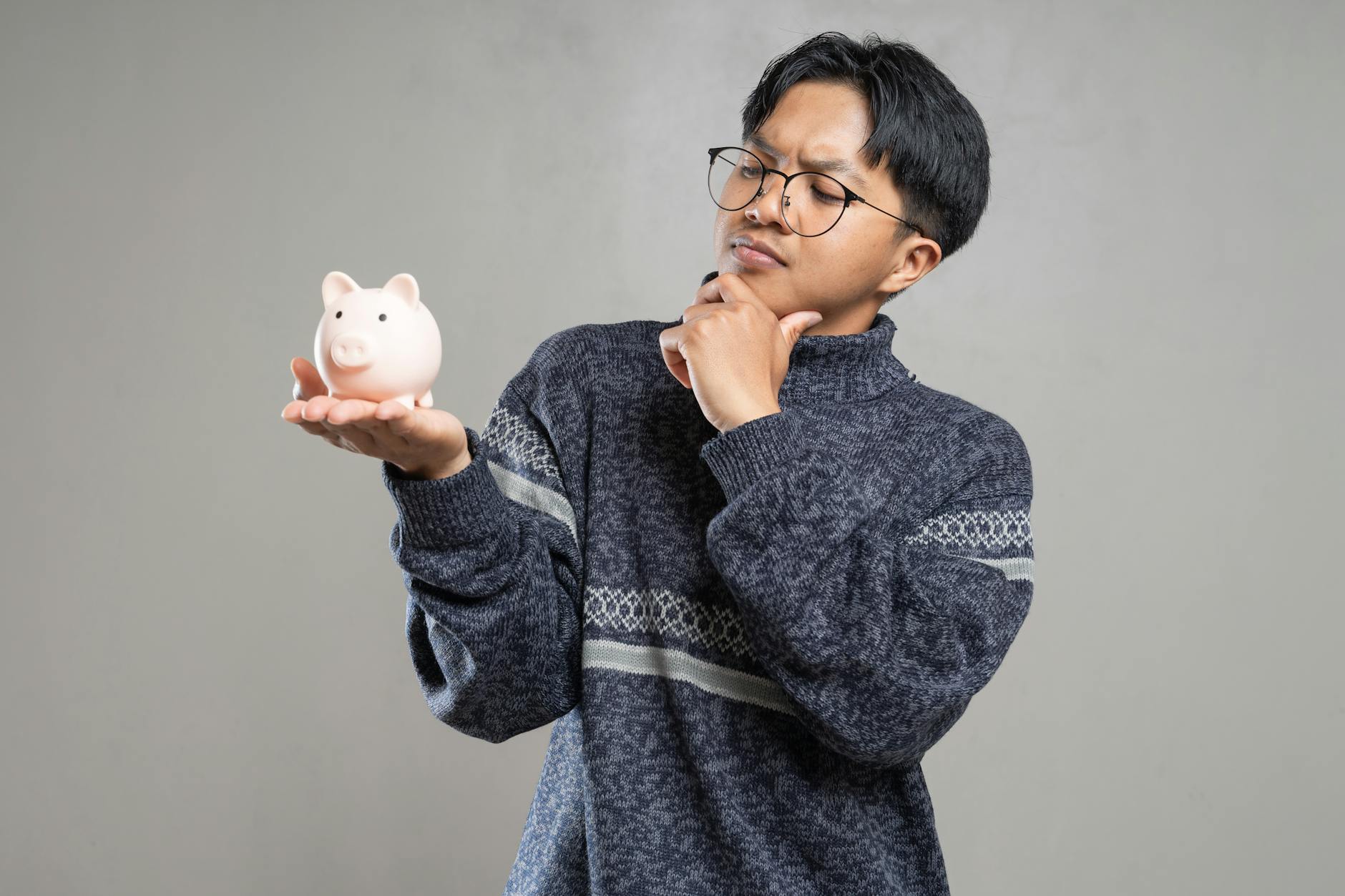 Person Looking At A Clock While Holding A Piggy Bank