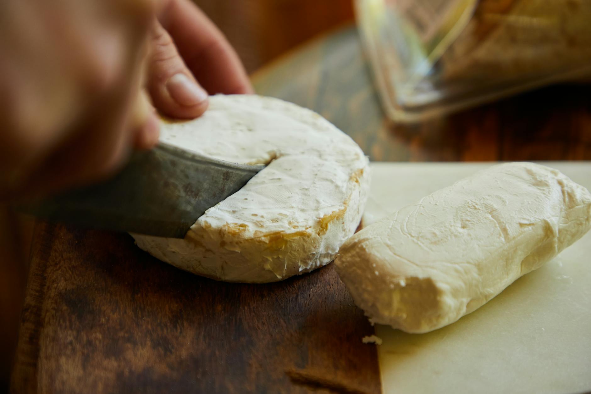 Cheese On A Wooden Cutting Board With A Knife And Small Pieces Cut Out