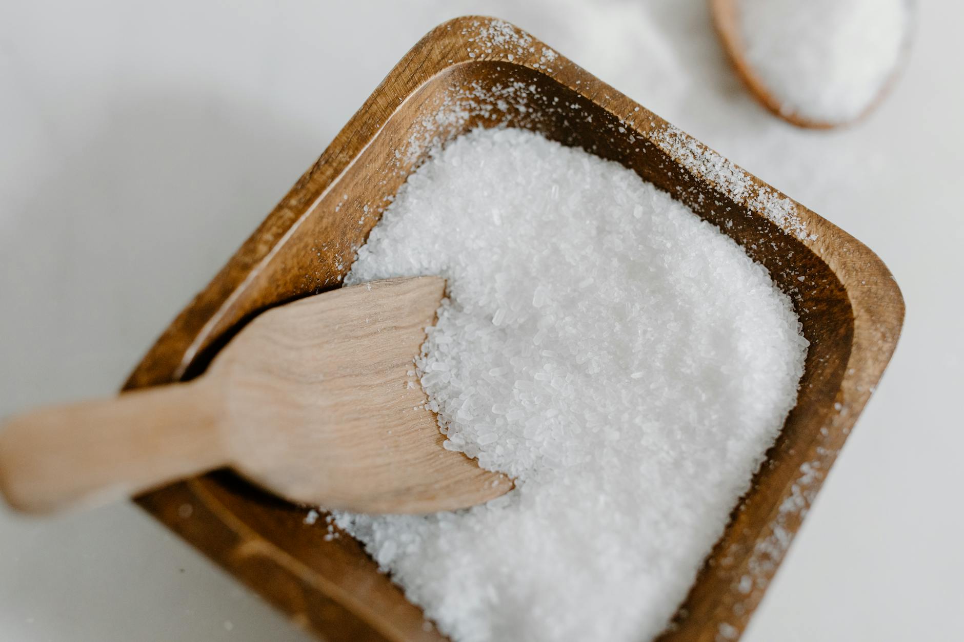 Kosher Salt In A Bowl With Coarse Grains And A Pinch Being Taken With Fingers