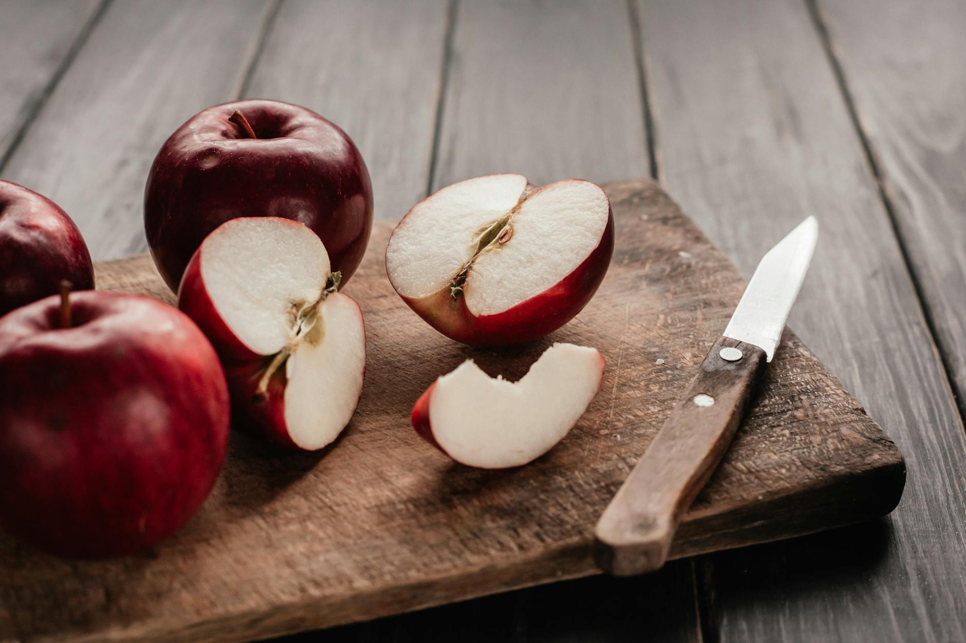 Honeycrisp Apple On A Wooden Cutting Board With A Knife And A Pie Dish In The Background