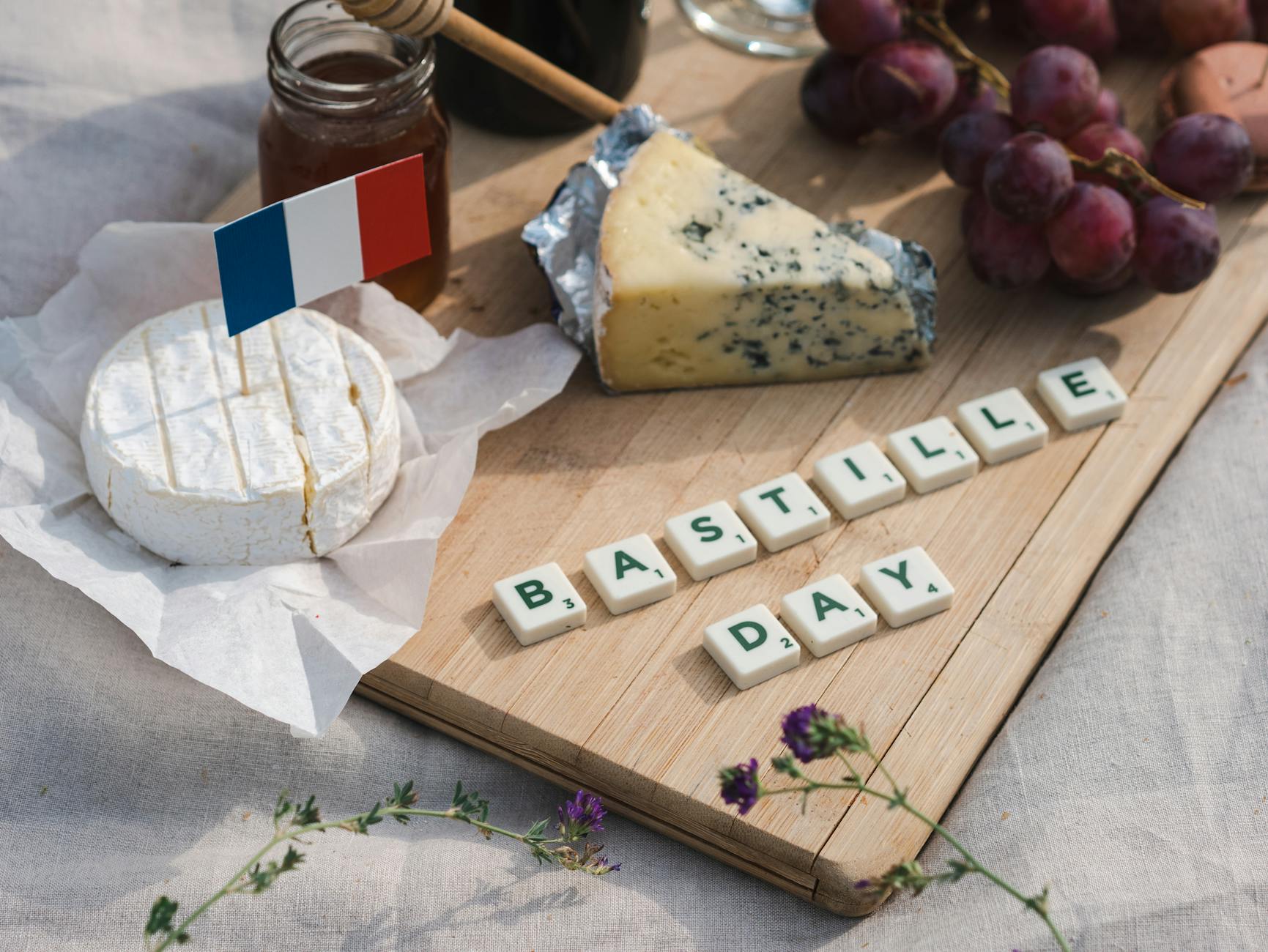 French Picnic Board With Baguette, Camembert, Pâté, Cornichons, Pearl Onions, Radishes, Butter, And Grapes